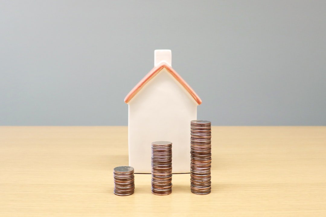 a-house-and-stacks-of-coins-on-a-table-uft0gythnve